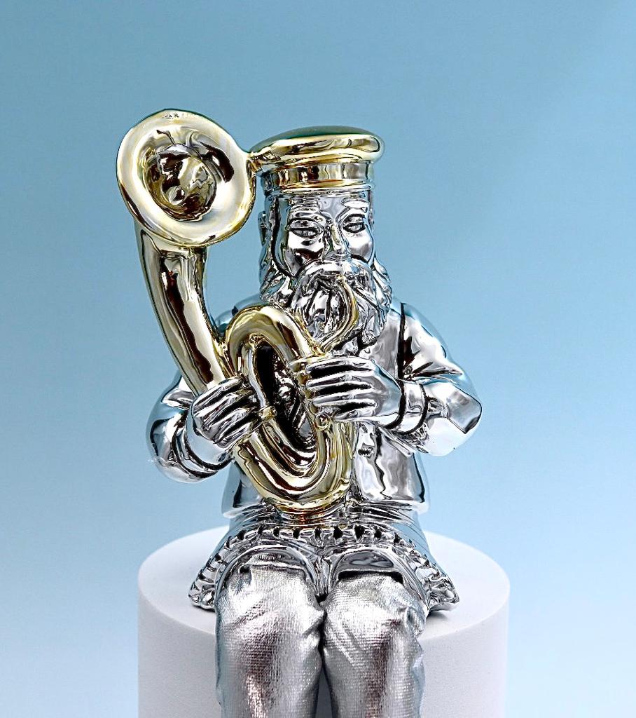 A Hasidic sits and plays a tuba
