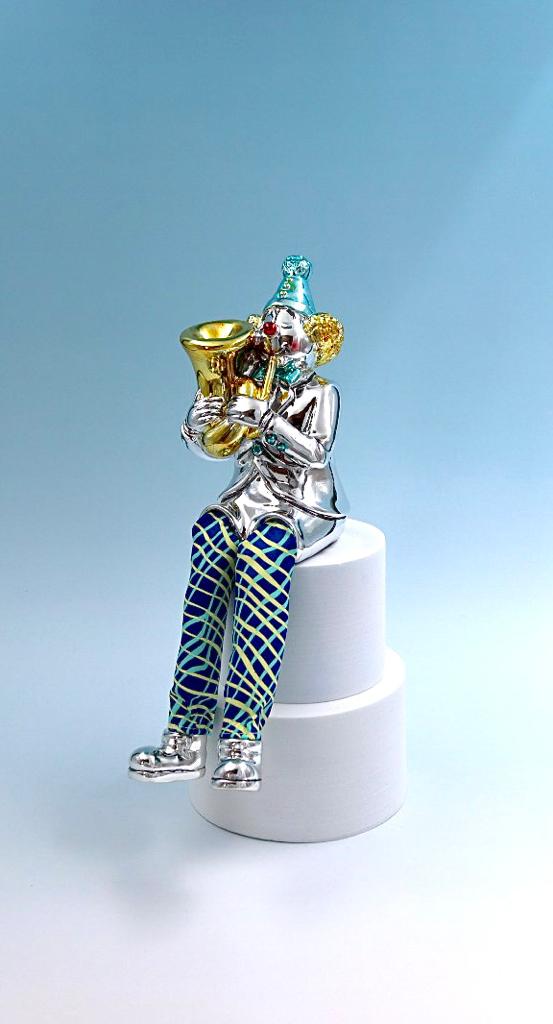 A seated clown plays the tuba