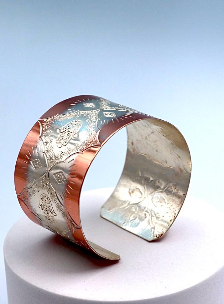 copper bracelet with silver engraved with Hamsa.