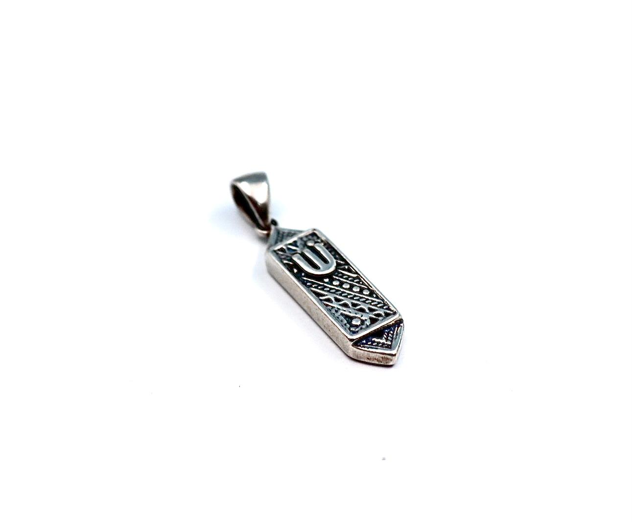 silver pendant resembling a mezuzah.