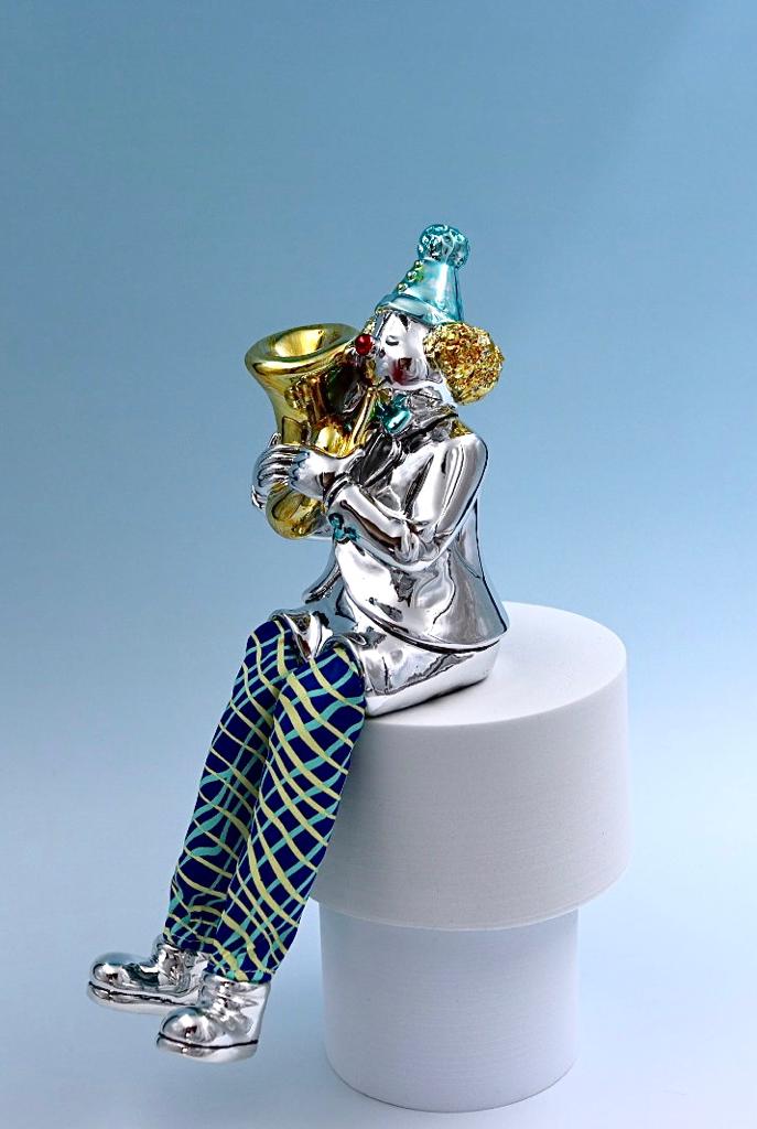 A seated clown plays the tuba