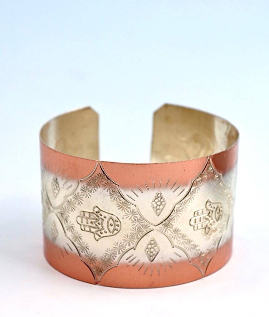 copper bracelet with silver engraved with Hamsa.