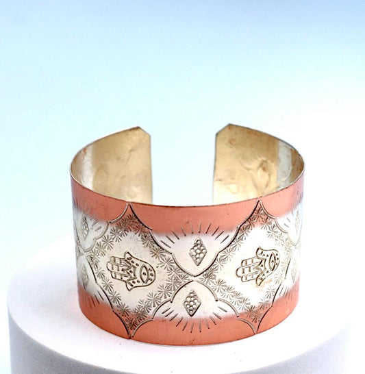 copper bracelet with silver engraved with Hamsa.