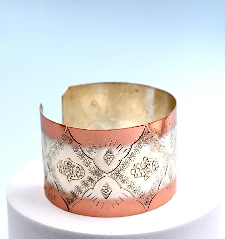 copper bracelet with silver engraved with Hamsa.