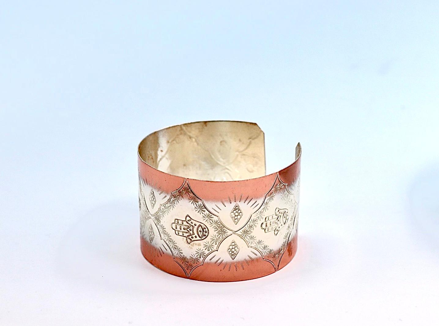 copper bracelet with silver engraved with Hamsa.