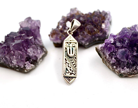 silver pendant resembling a mezuzah.