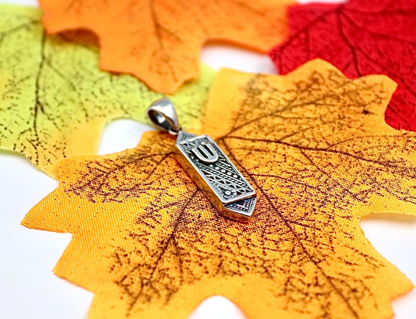 silver pendant resembling a mezuzah.