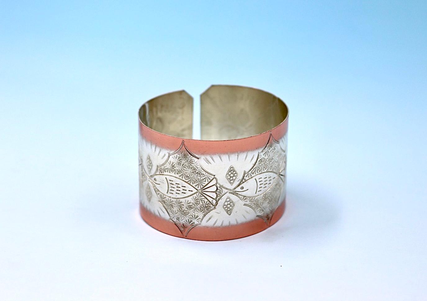 copper bracelet with A Fish design, partly silver-plated.