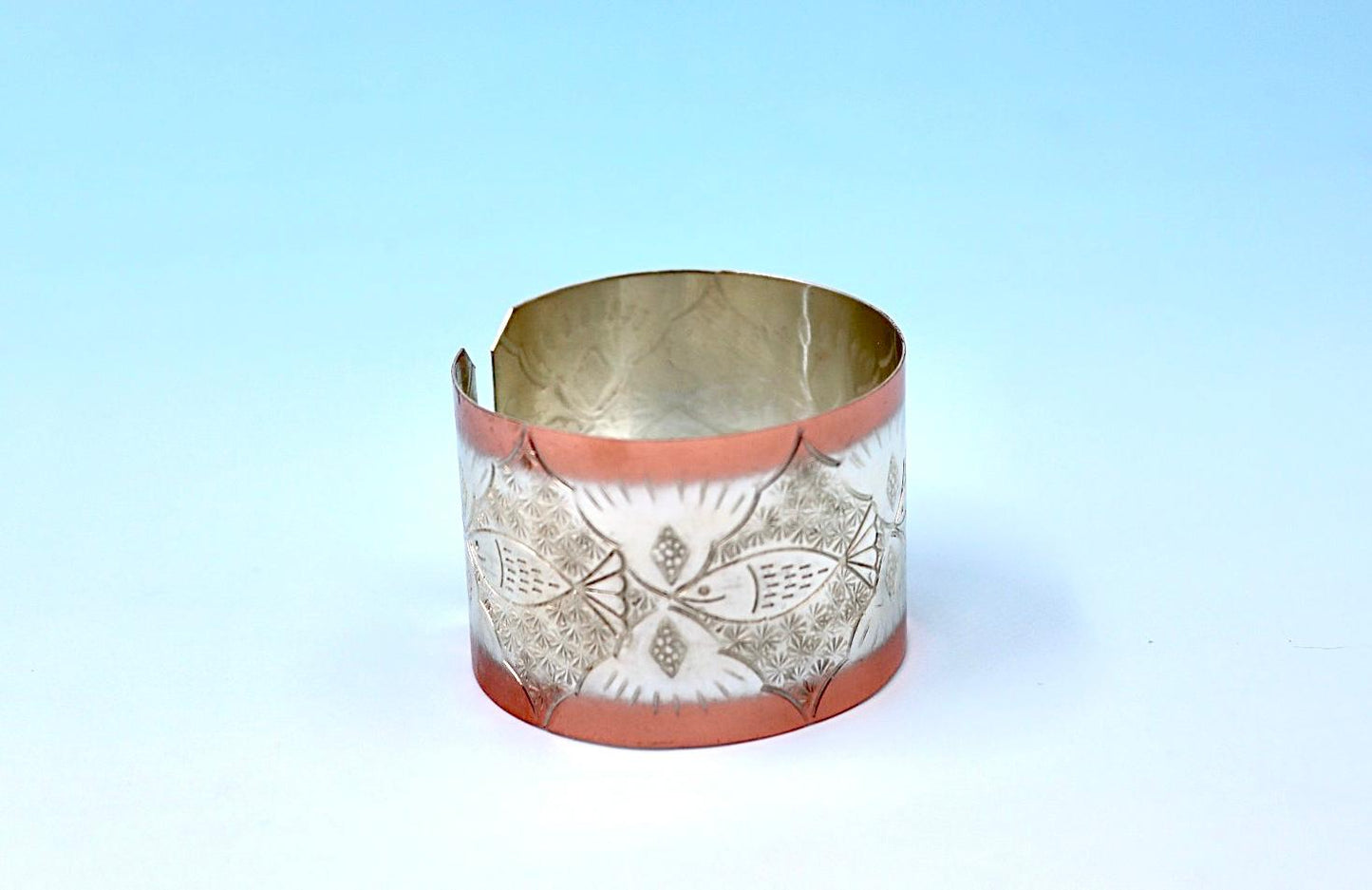 copper bracelet with A Fish design, partly silver-plated.