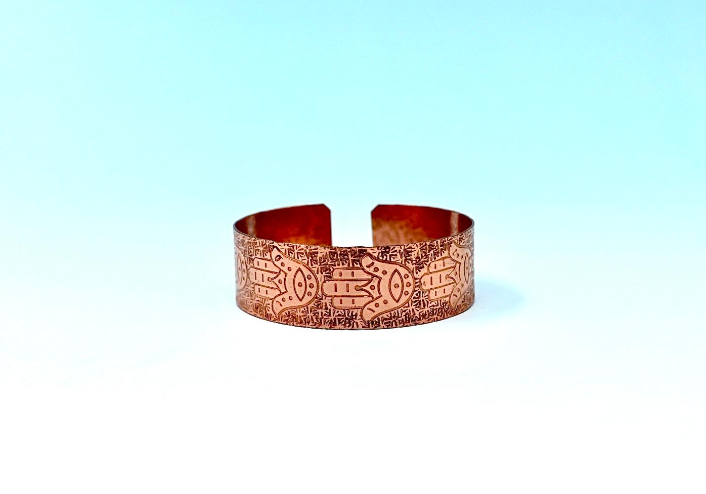 copper bracelet with hamsa.