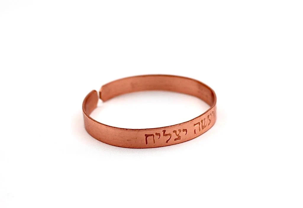 copper bracelet engraved "and in whatsoever he doeth he shall prosper" in Hebrew.